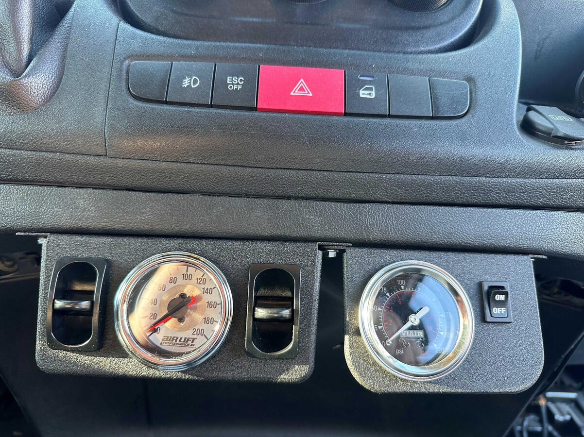 Custom Air Suspension Controls Custom in-cab air suspension controls and dual pressure gauges installed in a Ram ProMaster 3500 camper van with a VIAIR onboard air system.