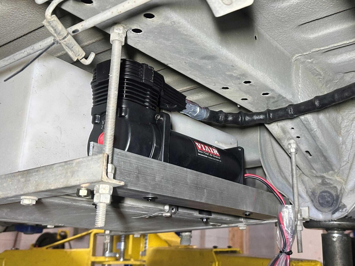 Onboard Air Compressor Installation VIAIR continuous-duty onboard air compressor mounted beneath a Ram ProMaster 3500 camper van as part of a custom air suspension control system.